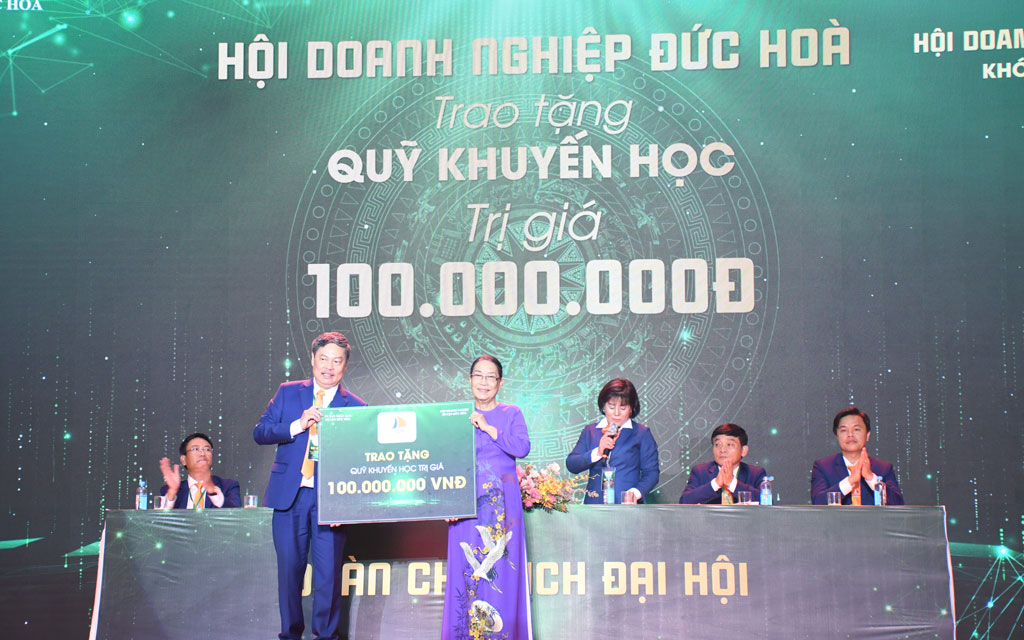 Ông Hoàng Hải (bìa trái) đại diện Ban Chấp hành Hội trao bảng tượng trưng 100 triệu đồng cho Quỹ Khuyến học huyện Đức Hòa